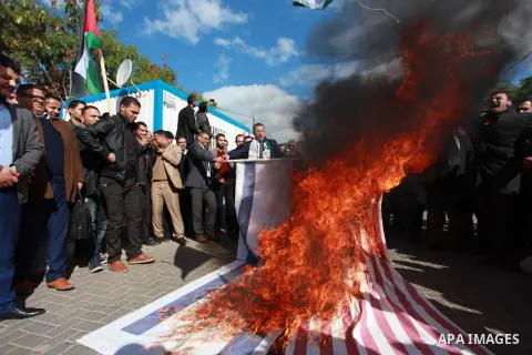 Palestinian protesters burn US and Israeli flags following Trump's decision to recognise Jerusalem as the capital of Israel, in front of the headquarter United Nation "UNSCO" in Gaza City, on December 7, 2017. Photo by M...