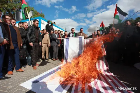 Palestinian protesters burn US and Israeli flags following Trump's decision to recognise Jerusalem as the capital of Israel, in front of the headquarter United Nation "UNSCO" in Gaza City, on December 7, 2017. Photo by M...