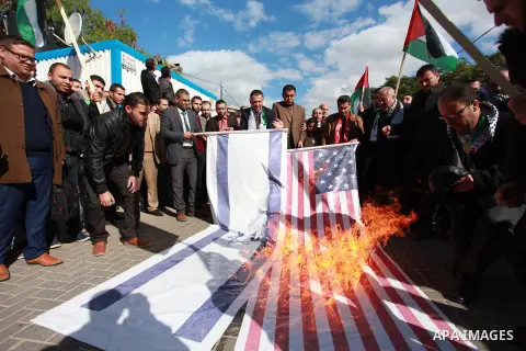 Palestinian protesters burn US and Israeli flags following Trump's decision to recognise Jerusalem as the capital of Israel, in front of the headquarter United Nation "UNSCO" in Gaza City, on December 7, 2017. Photo by M...