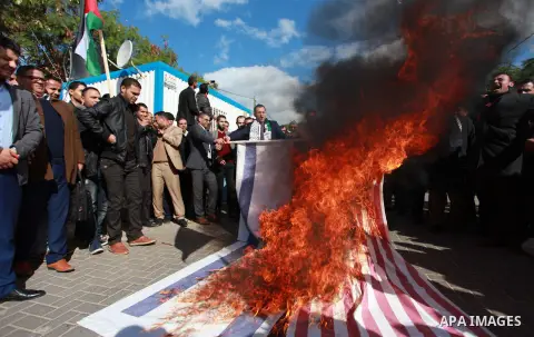 Palestinian protesters burn US and Israeli flags following Trump's decision to recognise Jerusalem as the capital of Israel, in front of the headquarter United Nation "UNSCO" in Gaza City, on December 7, 2017. Photo by M...