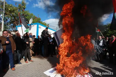 Palestinian protesters burn US and Israeli flags following Trump's decision to recognise Jerusalem as the capital of Israel, in front of the headquarter United Nation "UNSCO" in Gaza City, on December 7, 2017. Photo by M...