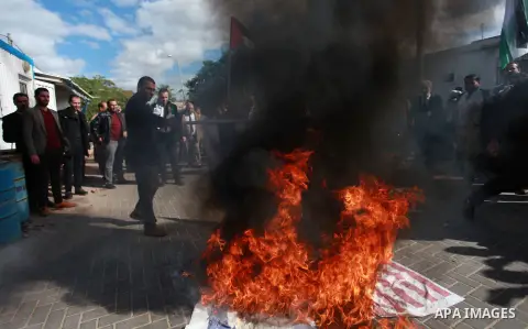 Palestinian protesters burn US and Israeli flags following Trump's decision to recognise Jerusalem as the capital of Israel, in front of the headquarter United Nation "UNSCO" in Gaza City, on December 7, 2017. Photo by M...