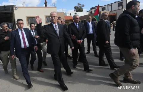 Palestinian Prime Minister Rami Hamdallah is surrounded by security as he waves following his arrival Gaza Strip on October 2, 2017. Photo by Mohammed Asad