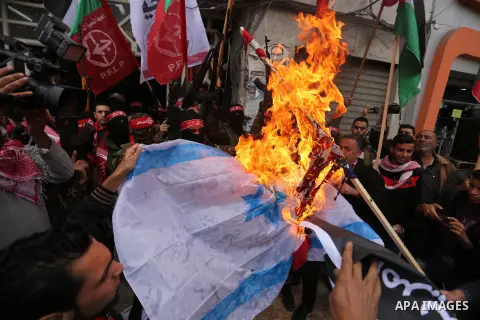 Palestinian militants of the Popular Front for the Liberation of Palestine (PFLP) burn an Israeli flag and a U.S. flag during a protest against following Trump's decision to recognise Jerusalem as the capital of Israel,...