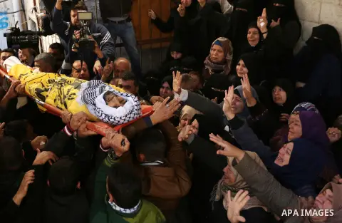 Palestinian mourners carry the body of Mahmoud al-Masri, a 30-year-old Palestinian man who was killed the previous day in clashes with Israeli troops, during his funeral in Khan Younis, in the southern Gaza Strip, on Dec...