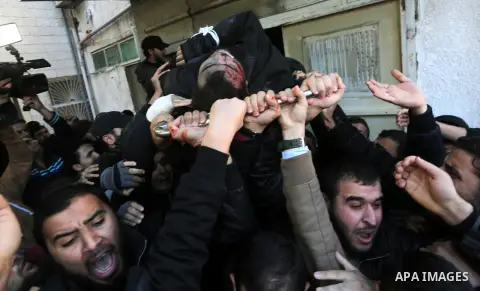 Palestinian militants from the Ezzedine al-Qassam Brigades, the armed wing of the Hamas movement, carry the body of their comrade Mohamed al-Safadi, who was killed the previous day in an Israeli air strike, during his fu...