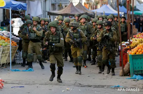 Israeli forces walk down a street during clashes with Palestinian demonstrators in Hebron in the Israeli-occupied West Bank on December 9, 2017, following the US president's controversial recognition of Jerusalem as Isra...