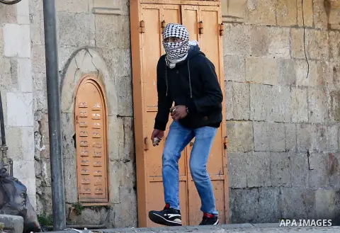 A Palestinian protester hurl stosnes towards Israeli secrity forces during clashes behind a checkpoint in the city centre of the West Bank town of Hebron on December 11, 2017 as demonstrations continue to flare in the Mi...