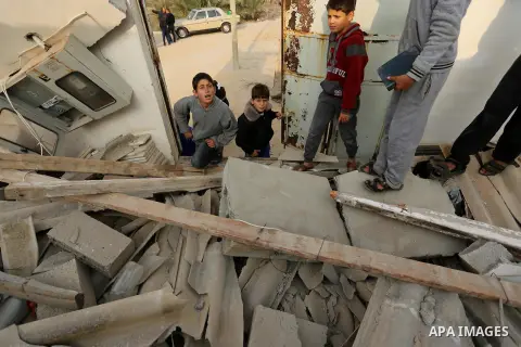 Palestinian children inspect their family house that was damaged in an Israeli airstrike on a nearby Hamas base, in Khan Yunis town in the southern Gaza Strip in December 13, 2017. Photo by Ashraf Amra