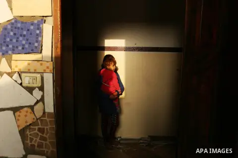 A Palestinian woman inspects her house that was damaged in an Israeli airstrike on a nearby Hamas base, in Khan Yunis town in the southern Gaza Strip in December 13, 2017. Photo by Ashraf Amra