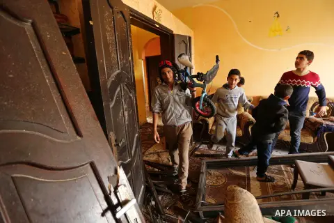 Palestinian children inspect their family house that was damaged in an Israeli airstrike on a nearby Hamas base, in Khan Yunis town in the southern Gaza Strip in December 13, 2017. Photo by Ashraf Amra