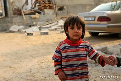 A Palestinian child while standing near a house that was damaged in an Israeli airstrike on a nearby Hamas base, in Khan Yunis town in the southern Gaza Strip in December 13, 2017. Photo by Ashraf Amra
