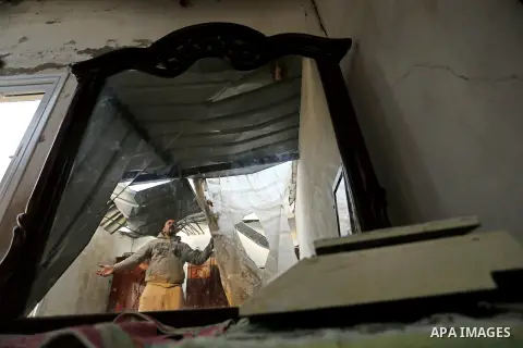 A Palestinian man inspects his house that was damaged in an Israeli airstrike on a nearby Hamas base, in Khan Yunis town in the southern Gaza Strip in December 13, 2017. Photo by Ashraf Amra