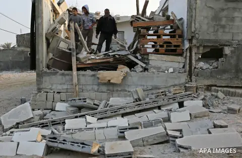 Palestinians inspect their house that was damaged in an Israeli airstrike on a nearby Hamas base, in Khan Yunis town in the southern Gaza Strip in December 13, 2017. Photo by Ashraf Amra