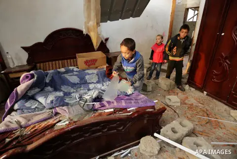 Palestinian children inspect their family house that was damaged in an Israeli airstrike on a nearby Hamas base, in Khan Yunis town in the southern Gaza Strip in December 13, 2017. Photo by Ashraf Amra