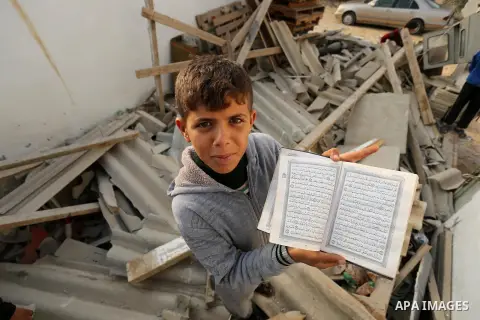 Palestinian children inspect their family house that was damaged in an Israeli airstrike on a nearby Hamas base, in Khan Yunis town in the southern Gaza Strip in December 13, 2017. Photo by Ashraf Amra