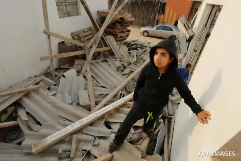 Palestinian children inspect their family house that was damaged in an Israeli airstrike on a nearby Hamas base, in Khan Yunis town in the southern Gaza Strip in December 13, 2017. Photo by Ashraf Amra