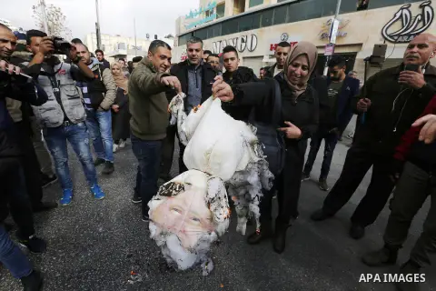 Palestinian protestors burn stuffed pillows in the shape of a pig and bearing an image of Israeli President Benjamin Netanyahu during a demonstration in the West Bank town of Hebron on December 13, 2017. Photo by Wisam H...