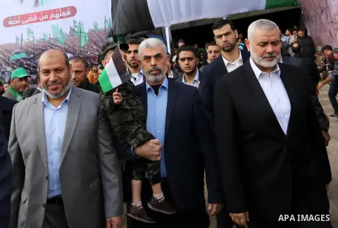 Head of the Political Bureau of Hamas, Ismail Haniyeh (R) and the leader of Hamas in the Gaza Strip, Yahya Sinwar (L) greet people as they attend an event held to mark the 30th anniversary of Hamas, at Al-Katiba Square o...