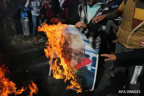 Palestinians burn posters depicting U.S. President Donald Trump during a protest against US President Donald Trump's decision to recognise Jerusalem as the capital of Israel, in al-Bureij in the central of Gaza strip, on...