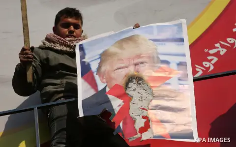 Palestinians burn posters depicting U.S. President Donald Trump during a protest against US President Donald Trump's decision to recognise Jerusalem as the capital of Israel, in al-Bureij in the central of Gaza strip, on...