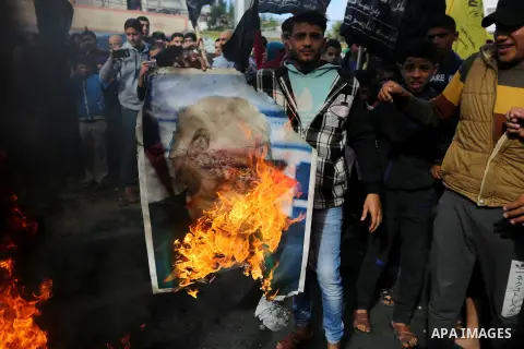 Palestinians burn posters depicting U.S. President Donald Trump during a protest against US President Donald Trump's decision to recognise Jerusalem as the capital of Israel, in al-Bureij in the central of Gaza strip, on...