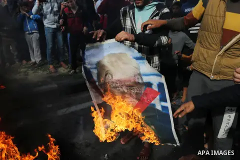 Palestinians burn posters depicting U.S. President Donald Trump during a protest against US President Donald Trump's decision to recognise Jerusalem as the capital of Israel, in al-Bureij in the central of Gaza strip, on...