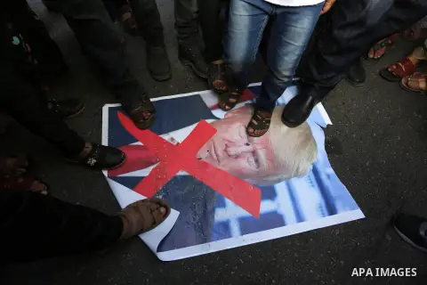 Palestinians step on a poster depicting U.S. President Donald Trump during a protest against US President Donald Trump's decision to recognise Jerusalem as the capital of Israel, in al-Bureij in the central of Gaza strip...