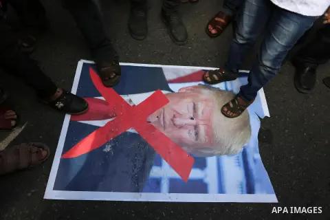 Palestinians step on a poster depicting U.S. President Donald Trump during a protest against US President Donald Trump's decision to recognise Jerusalem as the capital of Israel, in al-Bureij in the central of Gaza strip...