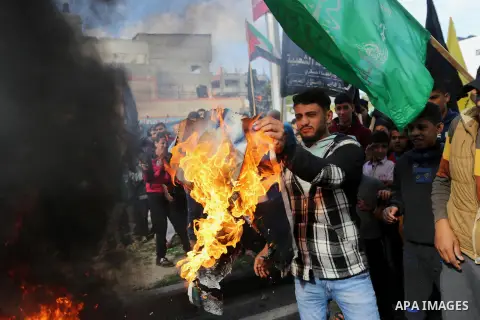 Palestinians burn posters depicting U.S. President Donald Trump during a protest against US President Donald Trump's decision to recognise Jerusalem as the capital of Israel, in al-Bureij in the central of Gaza strip, on...