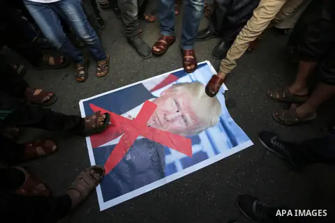 Palestinians step on a poster depicting U.S. President Donald Trump during a protest against US President Donald Trump's decision to recognise Jerusalem as the capital of Israel, in al-Bureij in the central of Gaza strip...