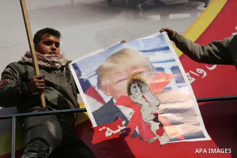Palestinians burn posters depicting U.S. President Donald Trump during a protest against US President Donald Trump's decision to recognise Jerusalem as the capital of Israel, in al-Bureij in the central of Gaza strip, on...