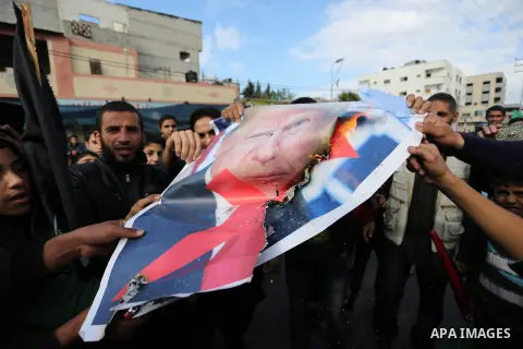 Palestinians burn posters depicting U.S. President Donald Trump during a protest against US President Donald Trump's decision to recognise Jerusalem as the capital of Israel, in al-Bureij in the central of Gaza strip, on...