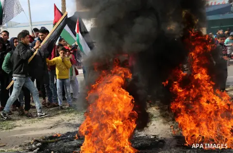 Palestinians burn posters depicting U.S. President Donald Trump during a protest against US President Donald Trump's decision to recognise Jerusalem as the capital of Israel, in al-Bureij in the central of Gaza strip, on...
