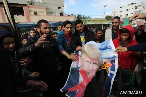 Palestinians burn posters depicting U.S. President Donald Trump during a protest against US President Donald Trump's decision to recognise Jerusalem as the capital of Israel, in al-Bureij in the central of Gaza strip, on...