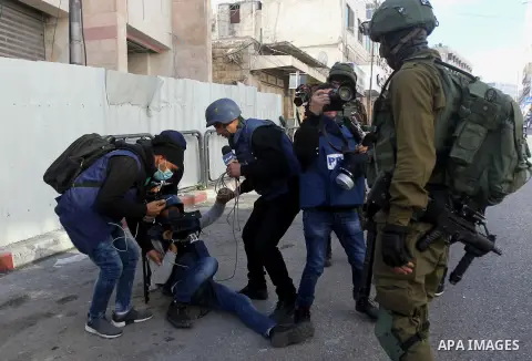 A Palestinian photographer is wounded during clashes between Palestinian protesters and Israeli security forces in the city centre of the occupied West Bank town of Hebron on December 15, 2017 as demonstrations continue...
