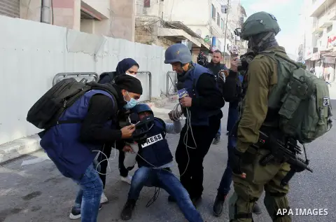 A Palestinian photographer is wounded during clashes between Palestinian protesters and Israeli security forces in the city centre of the occupied West Bank town of Hebron on December 15, 2017 as demonstrations continue...