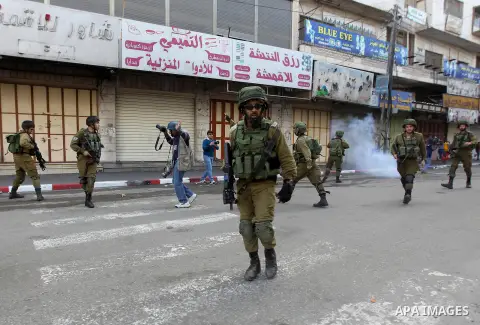 Israeli security forces take position during clashes with Palestinian protesters in the city centre of the occupied West Bank town of Hebron on December 15, 2017 as demonstrations continue to flare in the Middle East and...