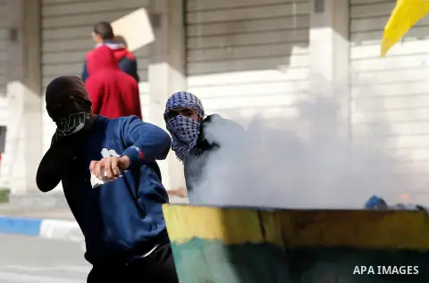 Palestinian protesters hurl stones towadrs Israeli security forces during clashes in the city centre of the occupied West Bank town of Hebron on December 15, 2017 as demonstrations continue to flare in the Middle East an...