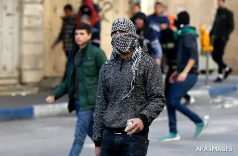 Palestinian protesters hurl stones towadrs Israeli security forces during clashes in the city centre of the occupied West Bank town of Hebron on December 15, 2017 as demonstrations continue to flare in the Middle East an...