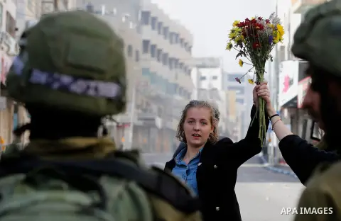 French female protesters hold a bouquet in front of Israeli security forces during a protest in the city centre of the occupied West Bank town of Hebron on December 15, 2017 as demonstrations continue to flare in the Mid...