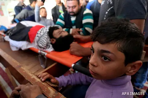 Palestinians peer over the body of 29-year-old Ibrahim Abu Thurayeh as they mourn during his funeral in Gaza City on December 16, 2017 after he was shot dead in clashes between Israeli forces and protesters along the Gaz...