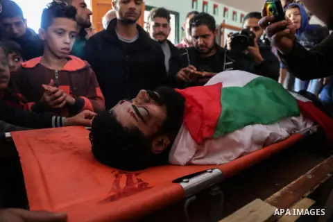 Palestinians peer over the body of 29-year-old Ibrahim Abu Thurayeh as they mourn during his funeral in Gaza City on December 16, 2017 after he was shot dead in clashes between Israeli forces and protesters along the Gaz...