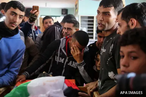 Palestinians peer over the body of 29-year-old Ibrahim Abu Thurayeh as they mourn during his funeral in Gaza City on December 16, 2017 after he was shot dead in clashes between Israeli forces and protesters along the Gaz...