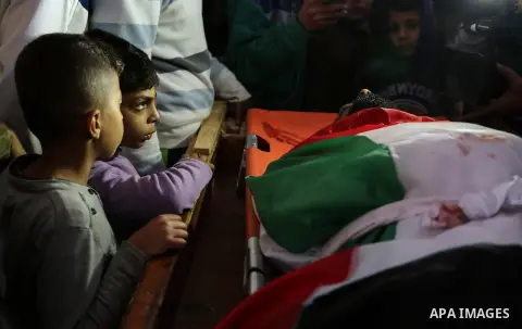 Palestinians peer over the body of 29-year-old Ibrahim Abu Thurayeh as they mourn during his funeral in Gaza City on December 16, 2017 after he was shot dead in clashes between Israeli forces and protesters along the Gaz...
