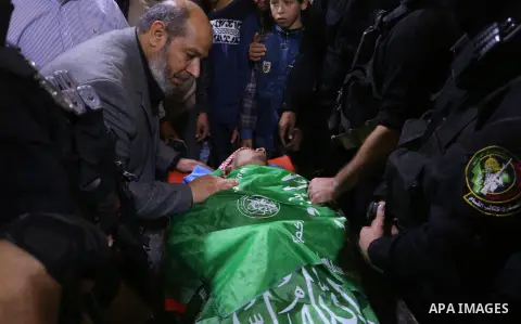Palestinian militants from the Ezzedine al-Qassam Brigades, the armed wing of the Hamas movement, gather around the body of Yasser Sukar as they mourn during his funeral in Gaza City on December 16, 2017 after he was sho...