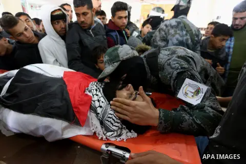 Palestinians peer over the body of 29-year-old Ibrahim Abu Thurayeh as they mourn during his funeral in Gaza City on December 16, 2017 after he was shot dead in clashes between Israeli forces and protesters along the Gaz...