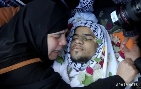 The mother of Mohammad Aqel, a Palestinian man who was killed after carrying out a stabbing attack on an Israeli soldier, mourns during the funeral of their brother in the village of Beit Ula, near Hebron in the Israeli...
