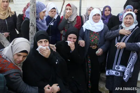 Palestinian relatives mourn on the body of Mohammad Aqel, a Palestinian man who was killed after carrying out a stabbing attack on an Israeli soldier, during the funeral of their brother in the village of Beit Ula, near...