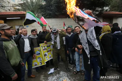 Palestinians burn an Israeli flag and a U.S. flag during a protest against Trump's decision to recognize Jerusalem as the capital of Israel, in front of Red cross office in Gaza city, on December 18, 2017. Photo by Moham...
